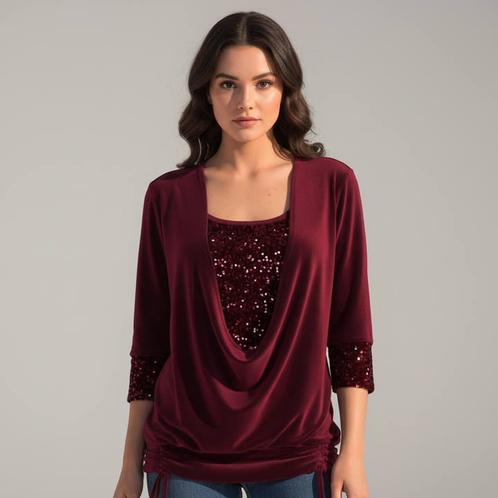 Woman wearing a sequined long-sleeved blouse against a plain background.