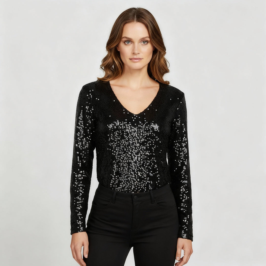 Woman wearing a glitter V-neck party top against a plain background.