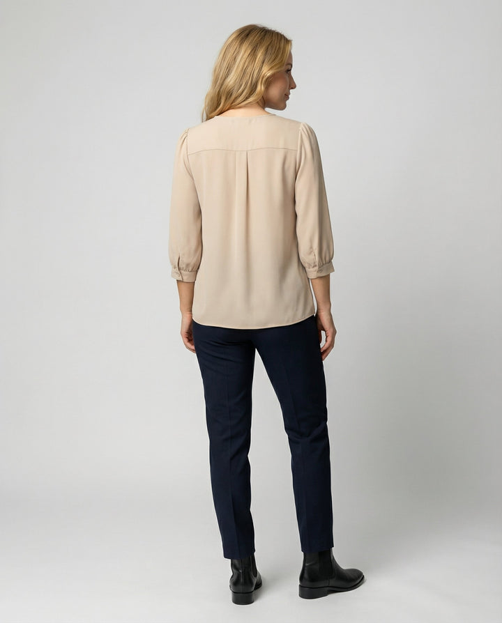Woman in a pleated satin blouse styled for smart casual wear.