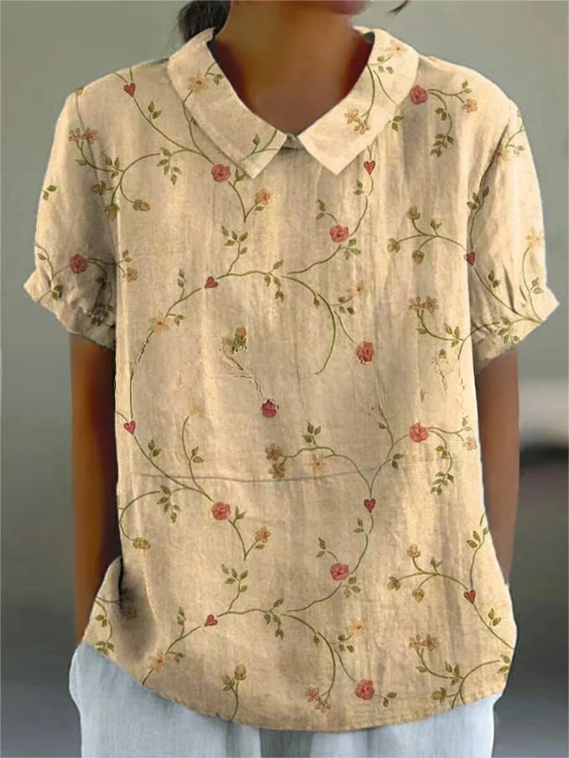  Female in a long-sleeve floral blouse against a plain background.