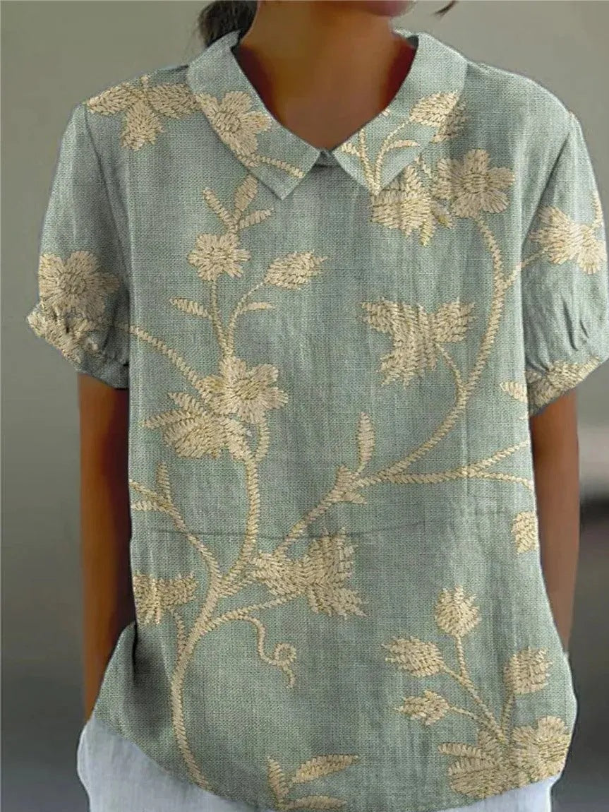 Woman wearing a floral shirt with a relaxed fit against a plain background.