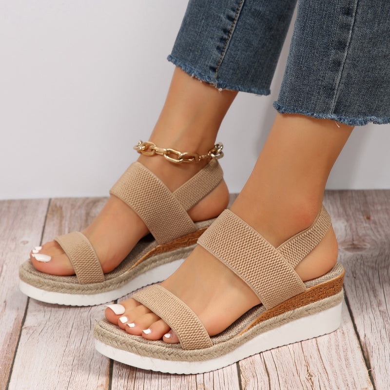 Female model in cushioned strap sandals on a plain background with a relaxed fashion pose.