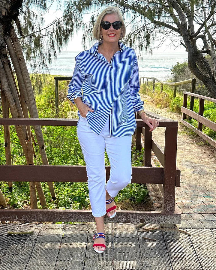 Woman in a relaxed striped button shirt against a plain background.