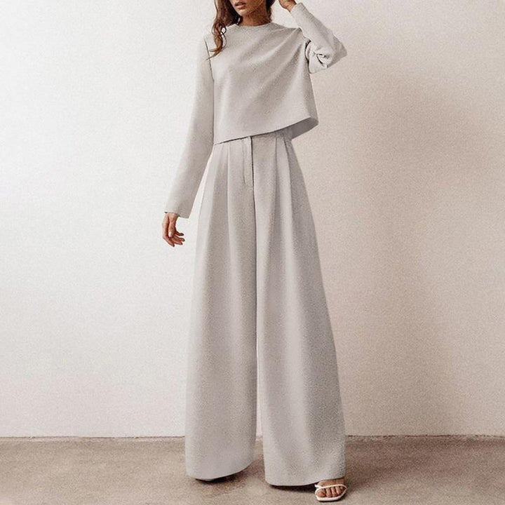 Woman modelling a long-sleeved top and wide-leg trousers against a plain background.