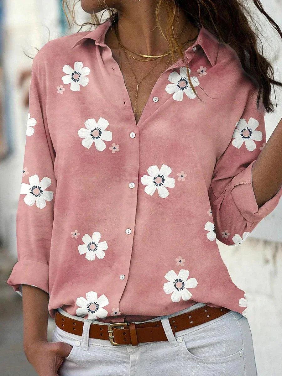 Female wearing a collared floral blouse with a button-front design.