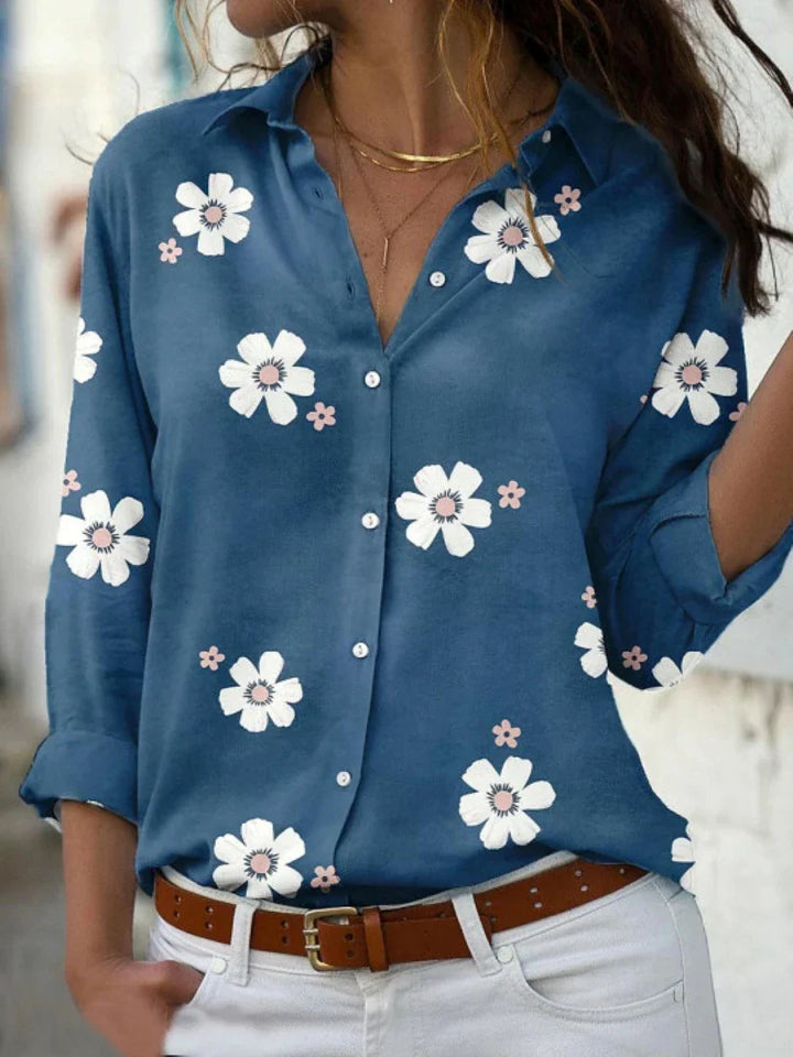  Female modelling a floral blouse with a classic collar and long sleeves.
