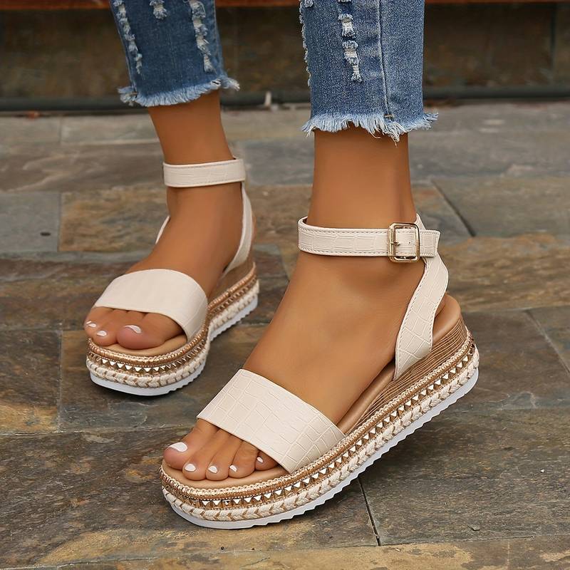 Female model wearing open toe platform sandals on a plain background.