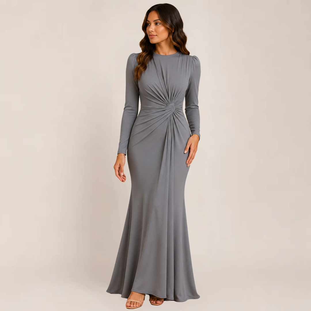 Woman wearing an elegant ruched dress with fitted styling on a plain background.
