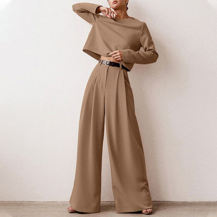 Woman in a fitted long-sleeved top paired with relaxed cropped trousers.