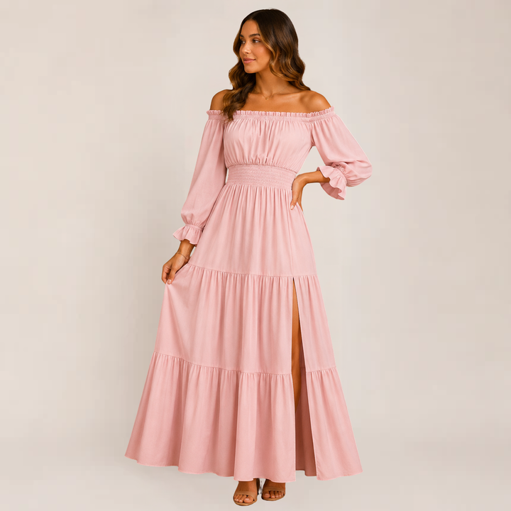 Female wearing an off-shoulder tiered summer dress on a plain background.