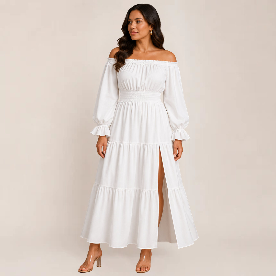 Female posing in a casual flowy dress with tiered detailing on a plain background.