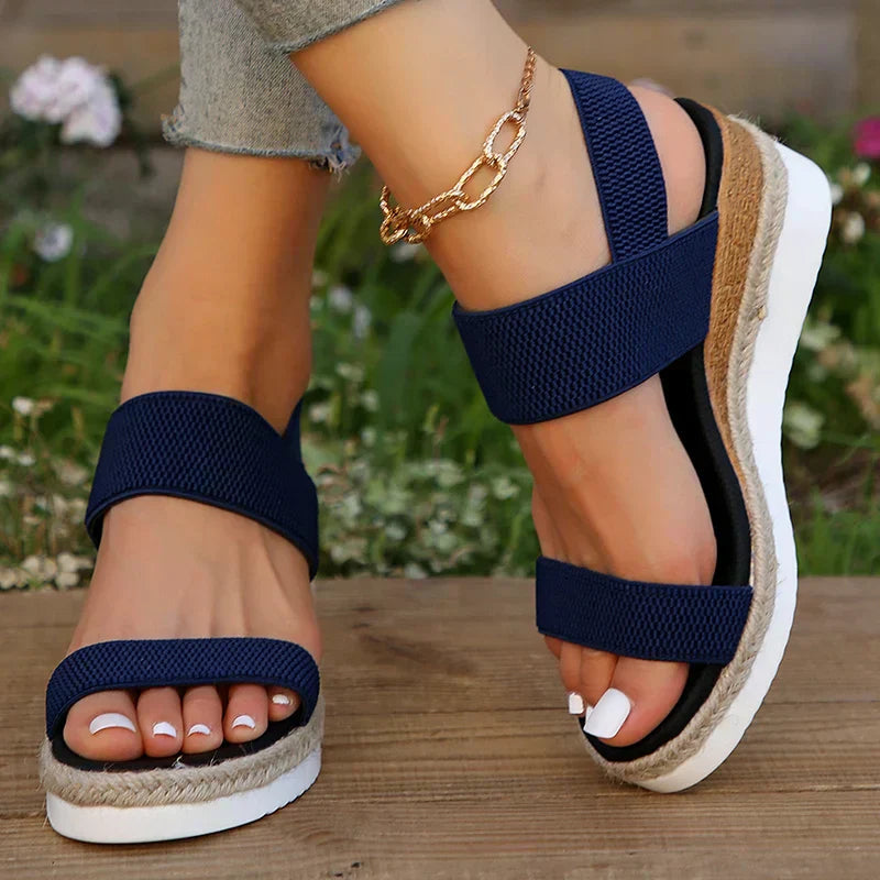 Woman wearing comfortable slip-on sandals on a plain background for casual outfit inspiration.