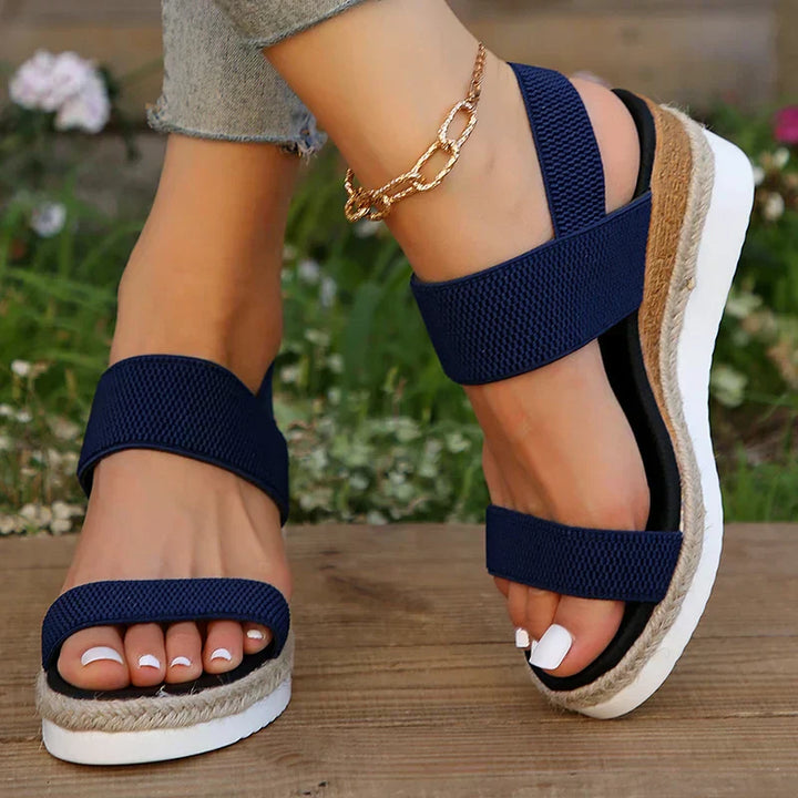 Woman wearing comfortable slip-on sandals on a plain background for casual outfit inspiration.
