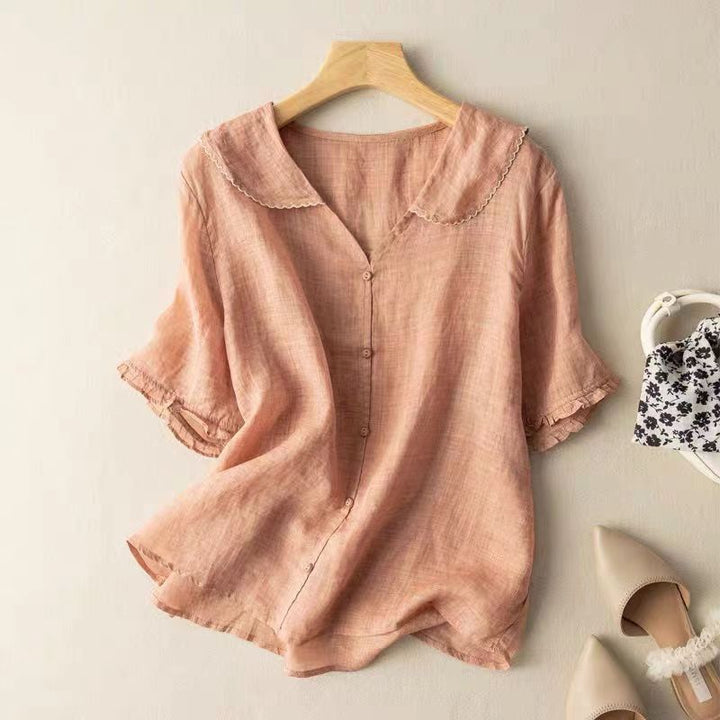 Relaxed-fit blouse with delicate collar detailing on a plain background.