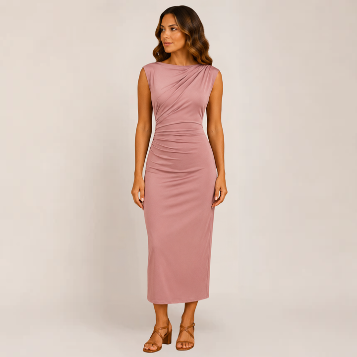 Model in a sleek fitted dress for cocktail occasions on a plain background.