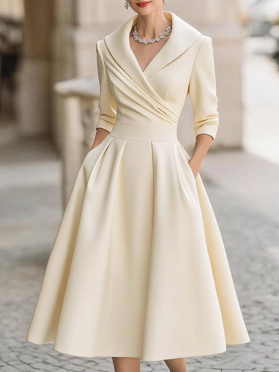 Woman wearing a refined midi dress with long sleeves and classic collar styling on a plain background.