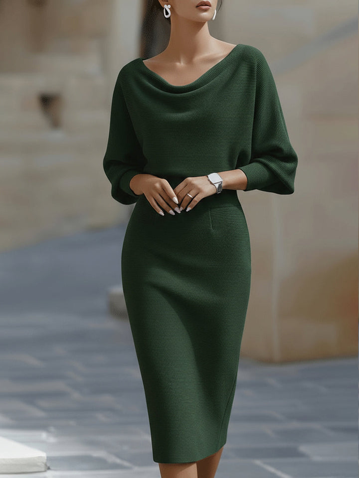 Female model in a white cowl neck midi dress with slim skirt on a plain background.