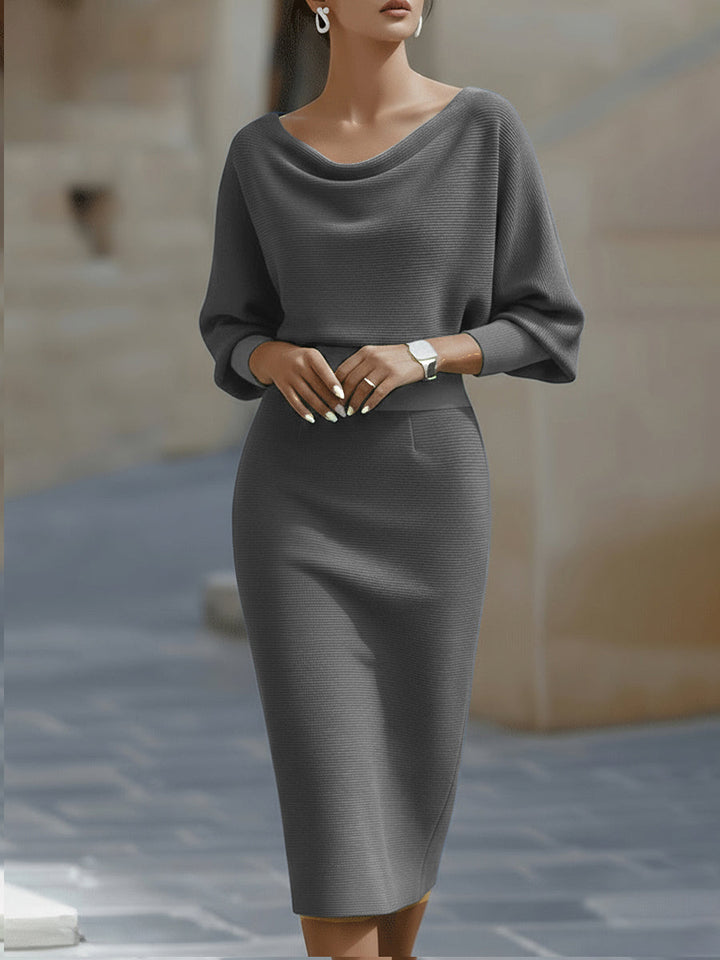 Female model in a white long sleeve dress with midi length on a plain background.