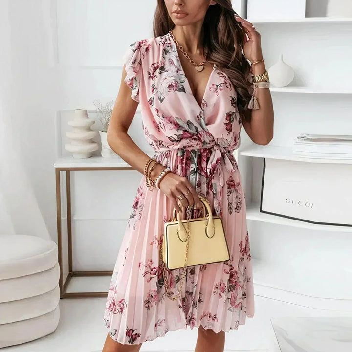 Female model wearing a floral midi dress with flutter sleeves on a plain background.