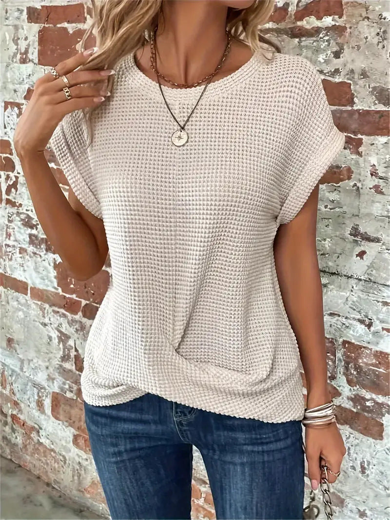  Female wearing a short sleeve textured top with a twisted front design.
