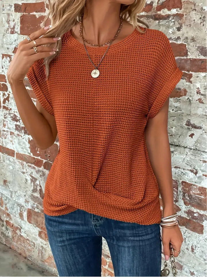  Woman modelling a casual everyday top with waffle texture and rolled sleeves.