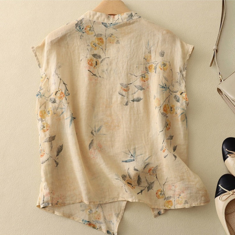  Female modelling a floral sleeveless blouse with an angled button closure.