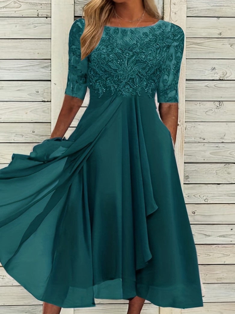 Female model in a formal ankle-length dress with delicate lace top on a plain background.
