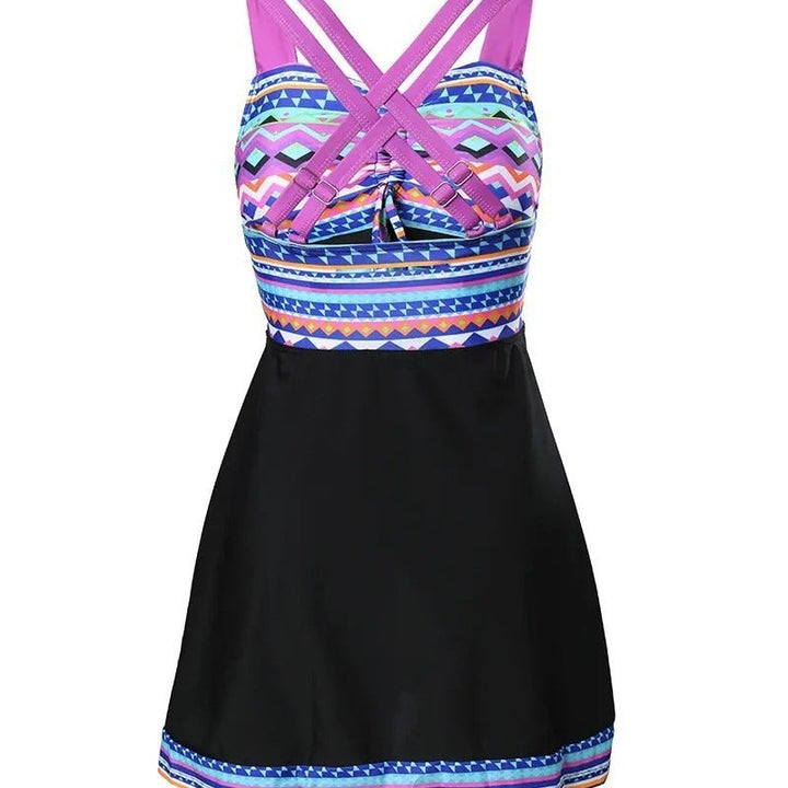 Model wearing a bold geometric swimwear dress with adjustable straps on a plain background.