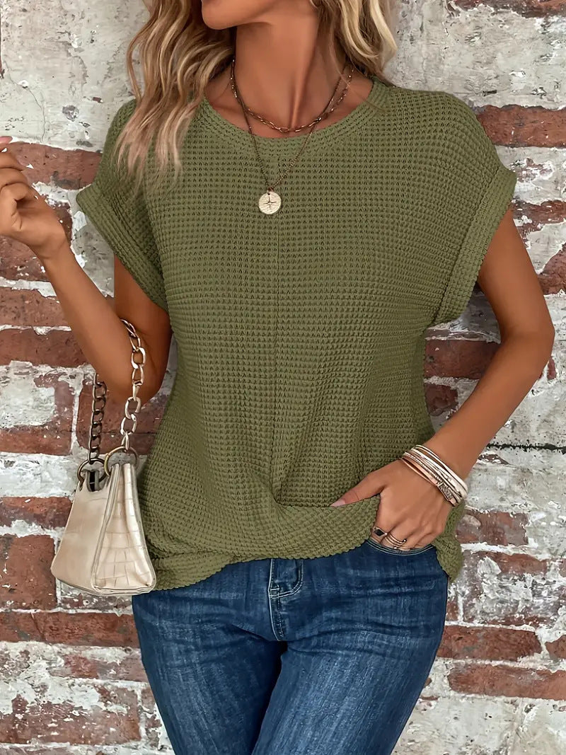  Woman in a relaxed fit waffle knit top with rolled sleeve styling.