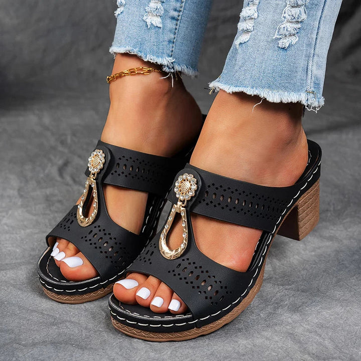 Female model wearing stylish wedge sandals on a plain background.