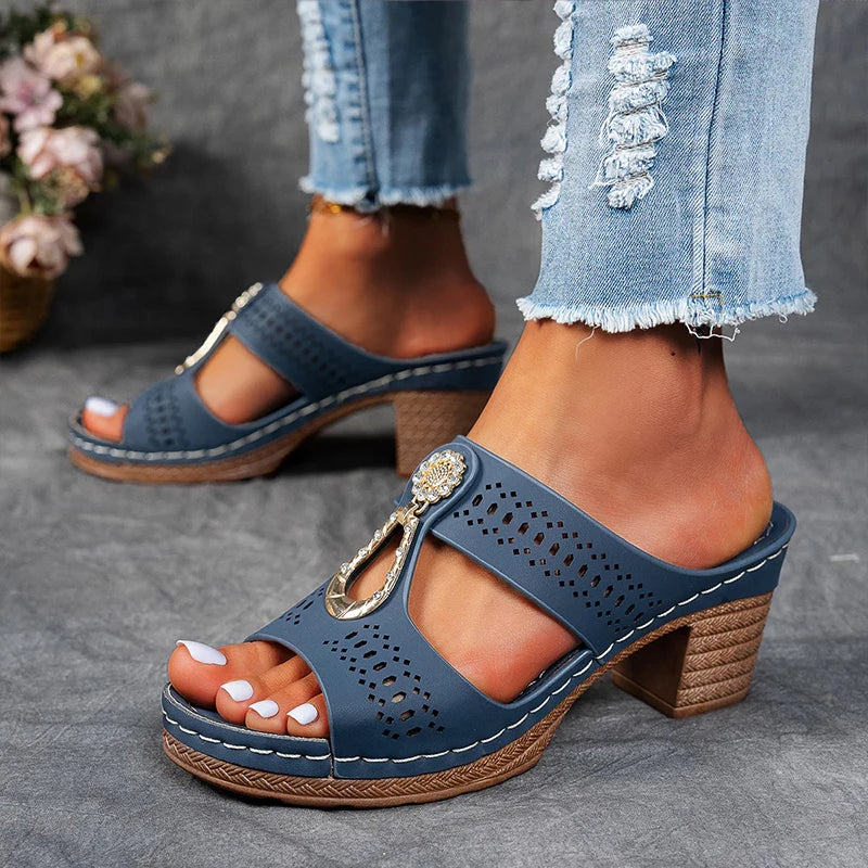 Woman wearing chic summer wedge sandals on a plain background.