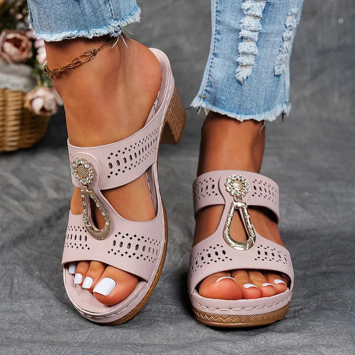 Female model displaying casual wedge sandals on a plain background.