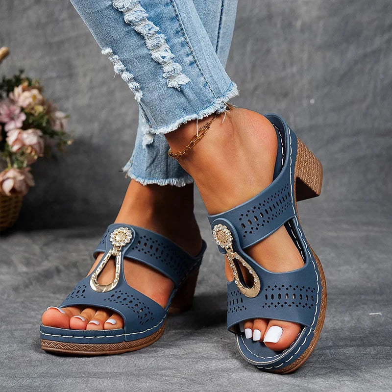 Woman posing in open-design wedge sandals on a plain background.