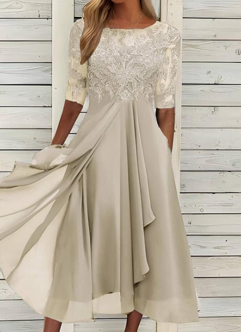 Model showcasing a formal event dress with a flattering long silhouette on a plain background.