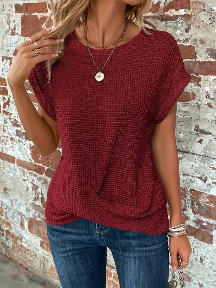  Female in a relaxed textured tee with a flattering front twist. 