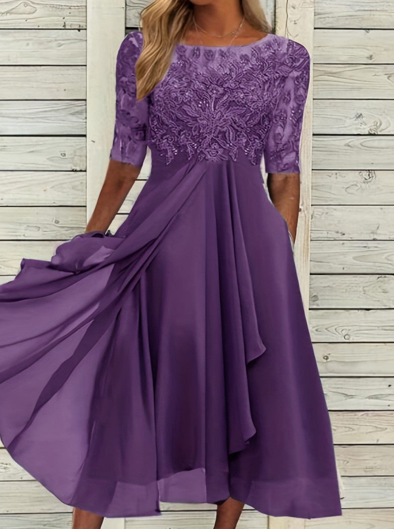 Female model wearing a refined evening dress with lace upper detail on a plain background.