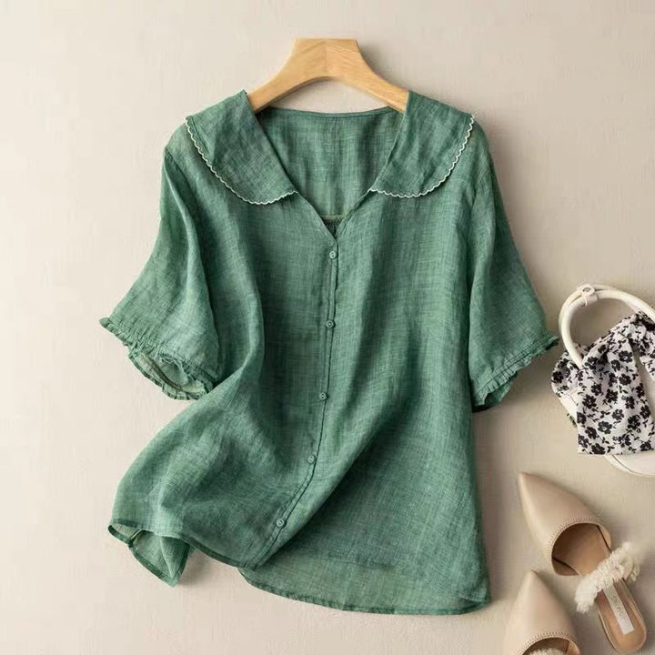 Vintage-inspired blouse with a scalloped collar against a plain background.