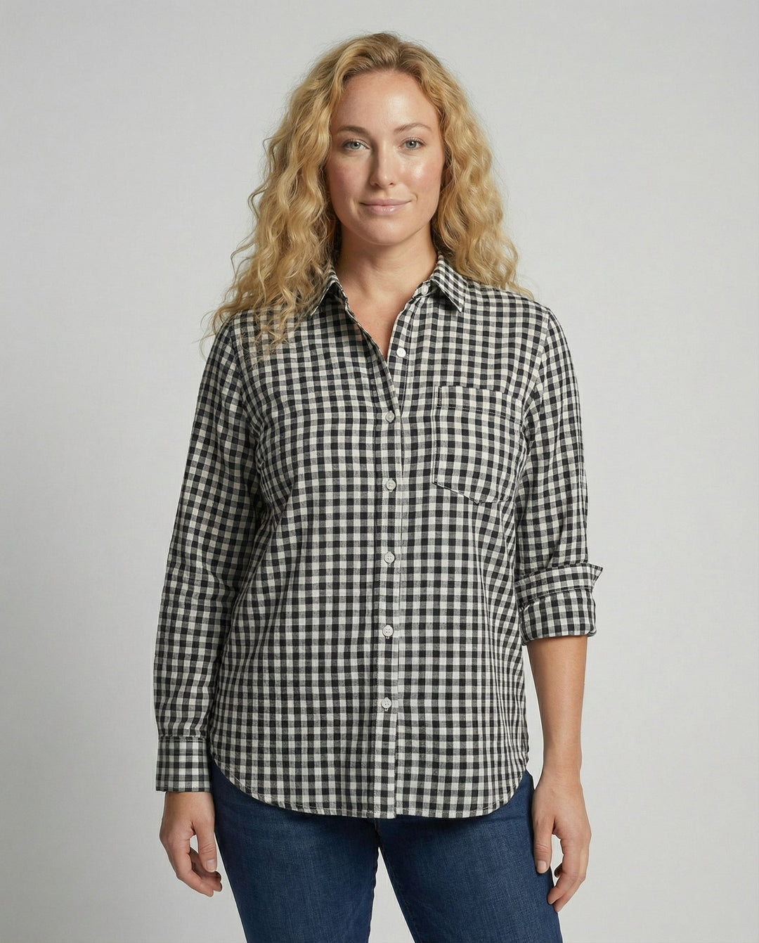 Woman wearing an oversized checked shirt blouse against a plain background.