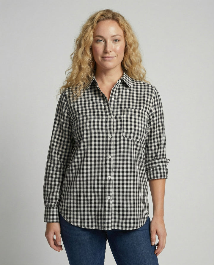 Woman wearing an oversized checked shirt blouse against a plain background.