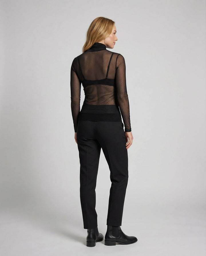 Woman in a fitted turtleneck top styled on a plain background.