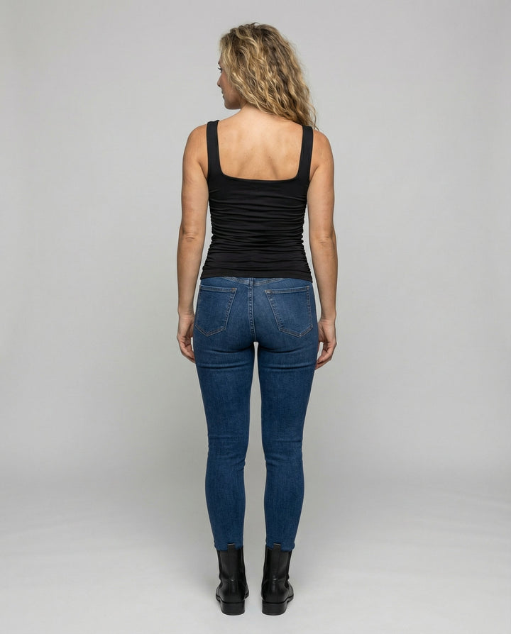Woman in a figure-hugging casual top on a plain background.