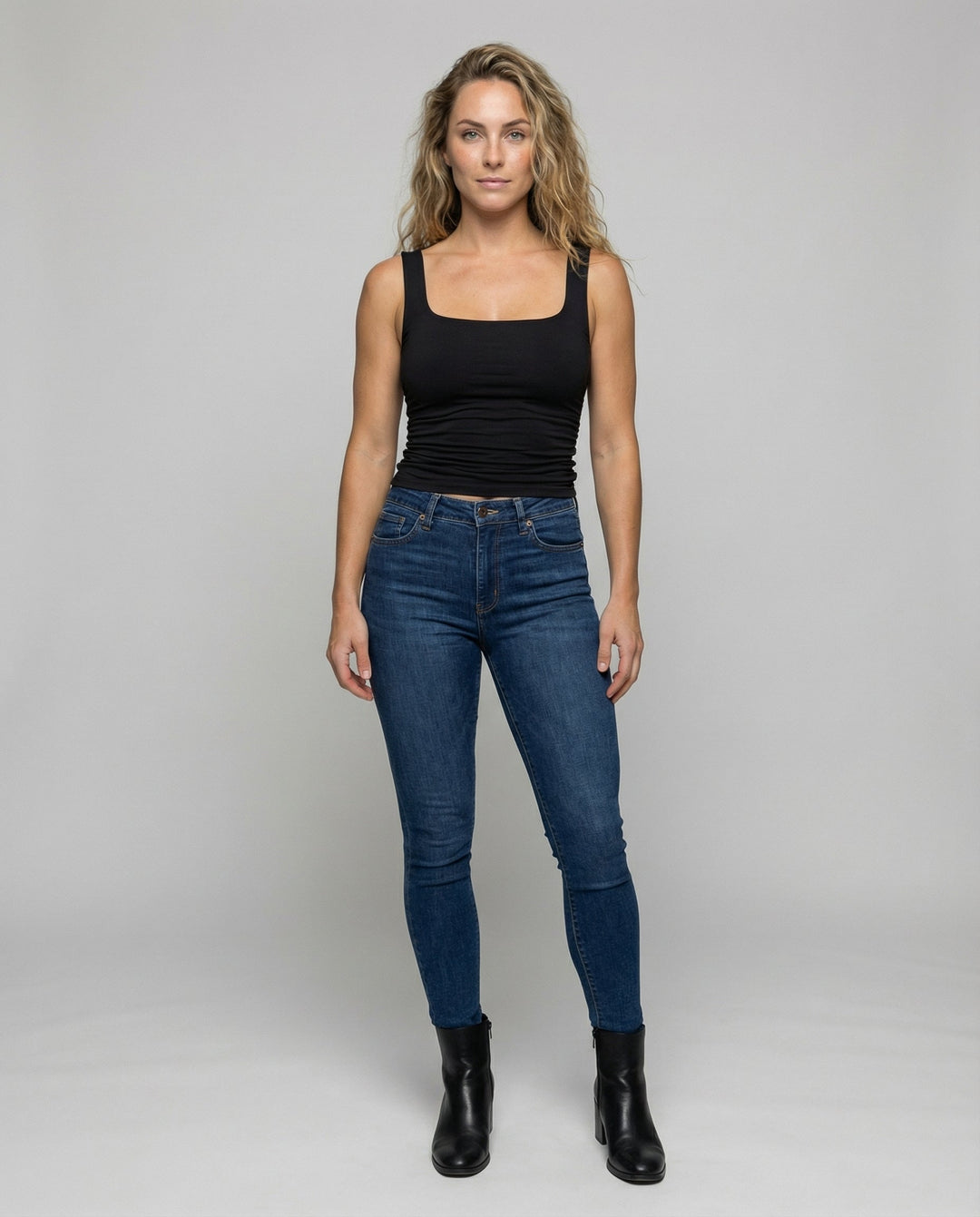 Female modelling a sleeveless fitted top with wide straps.