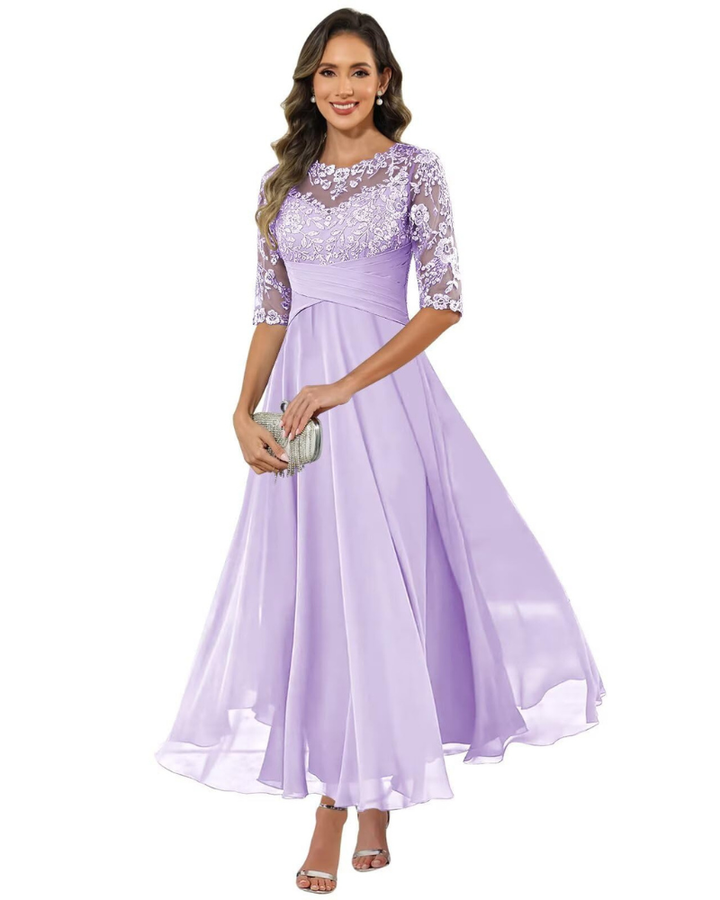 Female model in a long occasion dress with sheer sleeve styling on a plain background.