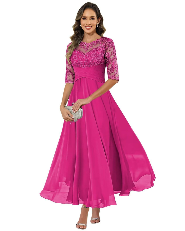 Model wearing a long dress with soft flowing movement on a plain background.
