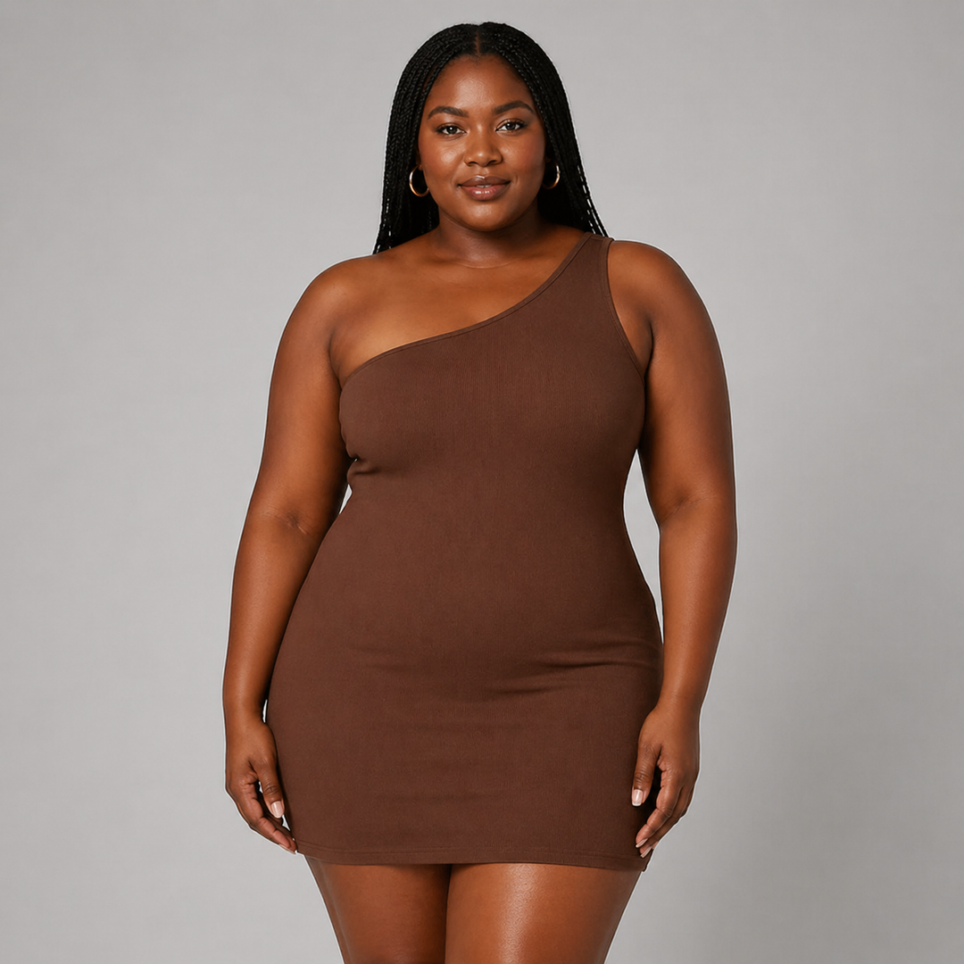 Woman posing in an asymmetrical mini dress on a plain background.