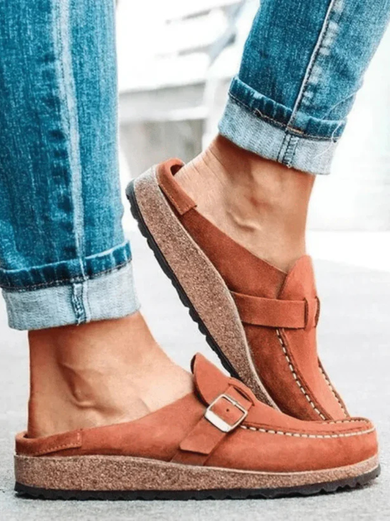 Female model wearing casual clogs with a simple outfit on a plain background.