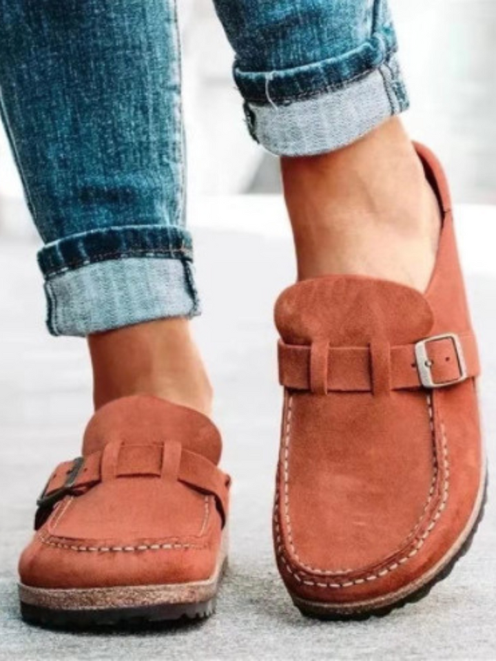 Female model standing in lightweight clogs against a plain background.