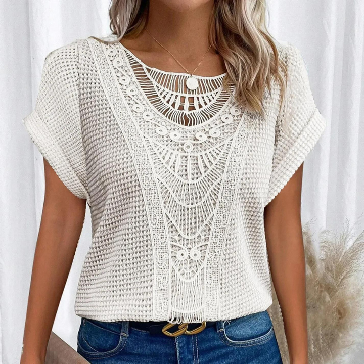  Woman modelling a lightweight summer top with lace accents.