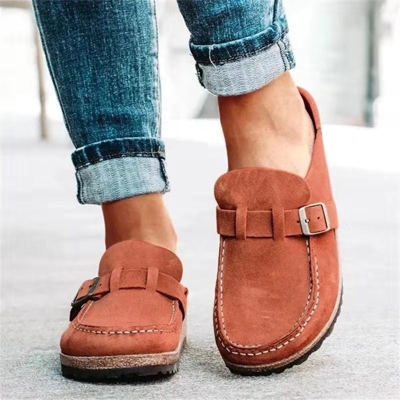 Woman wearing everyday loafers with adjustable buckle strap on a plain background.