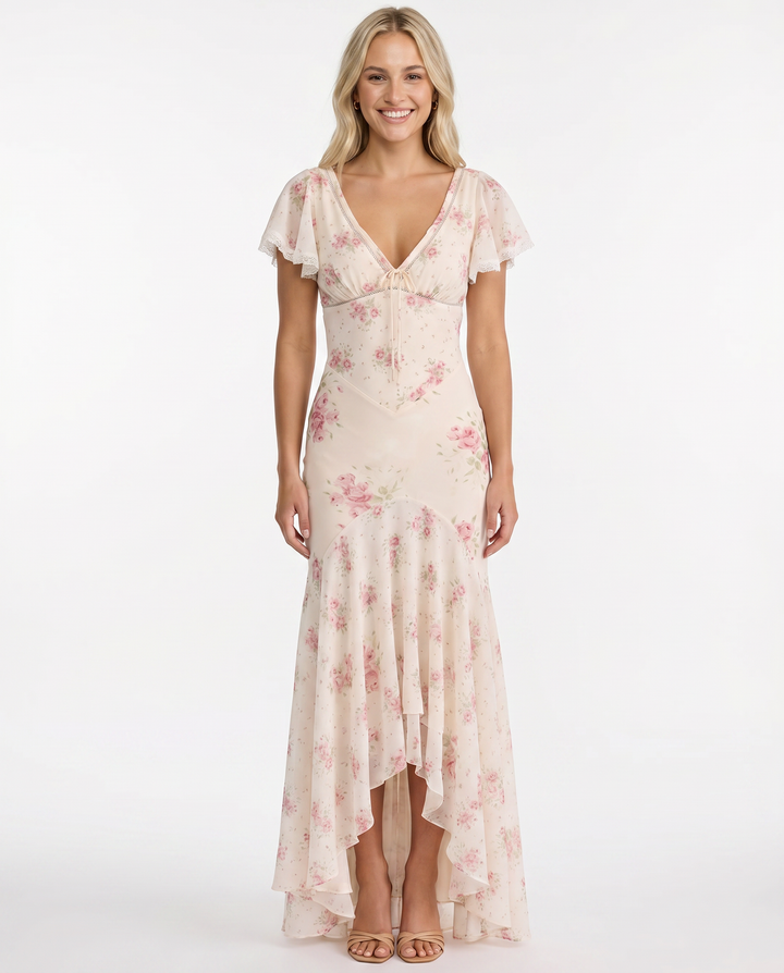 Female wearing a summer dress with an all-over floral pattern against a plain background.